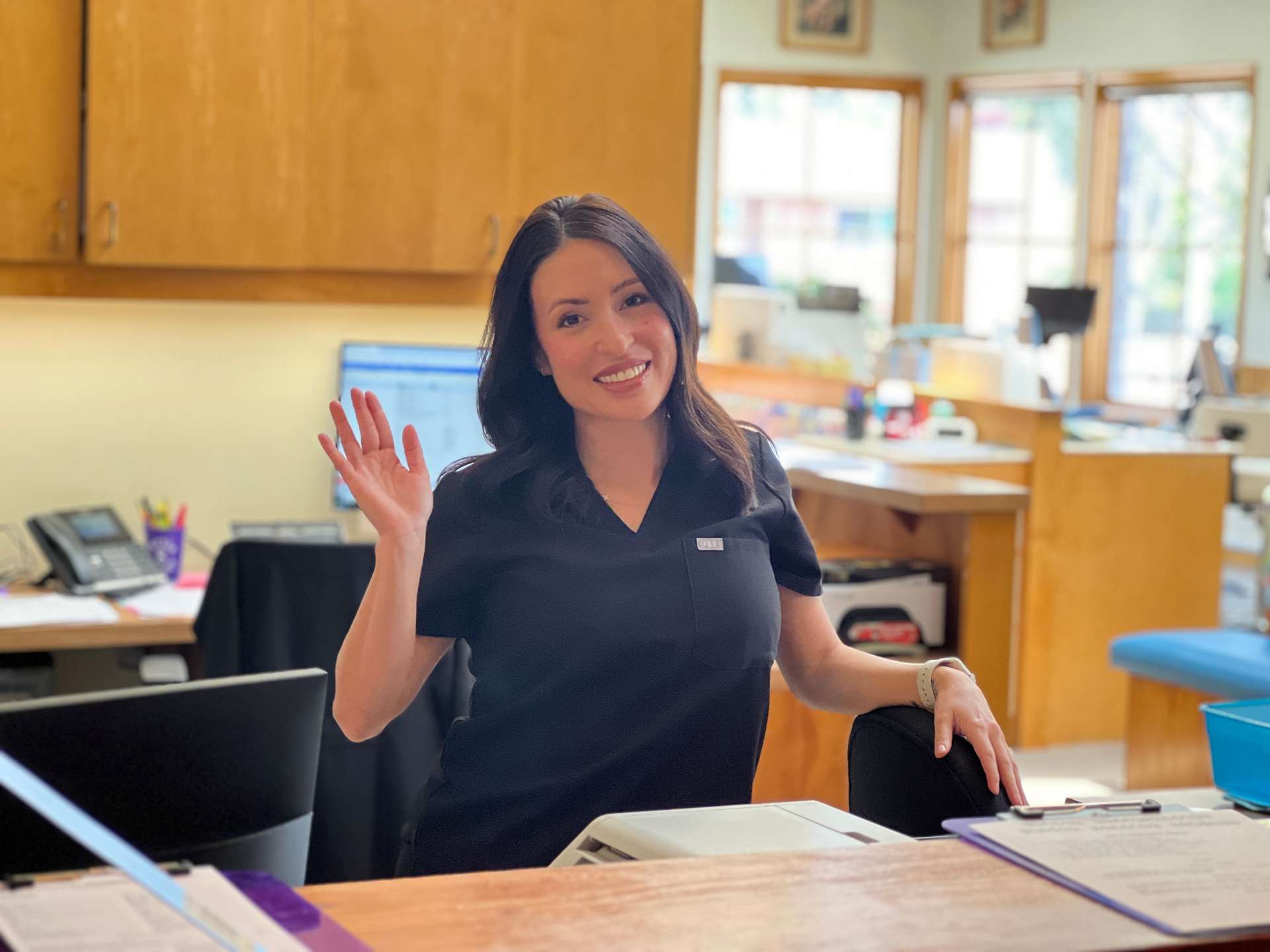 Team member at the front desk waving