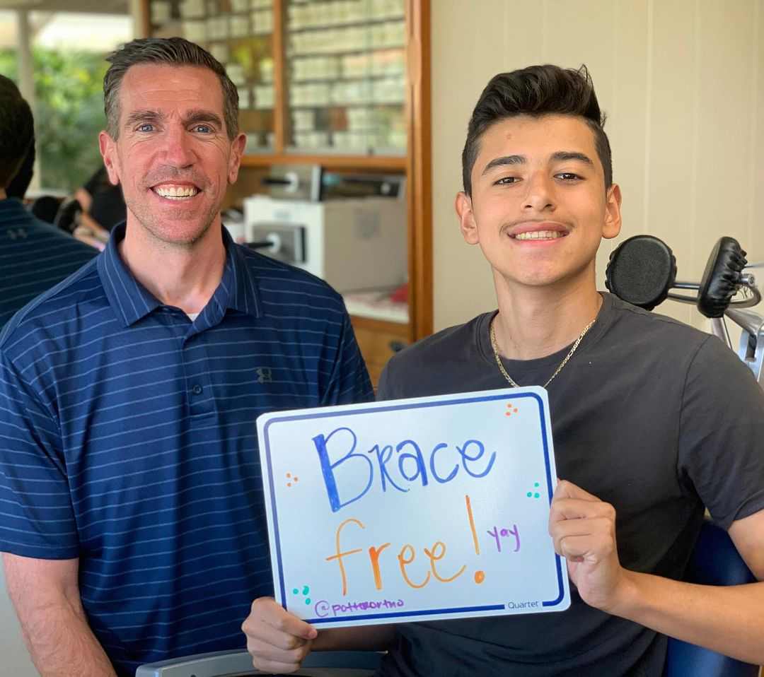 Dr. Potter smiling with a patient holding up, "Brace Free!" sign
