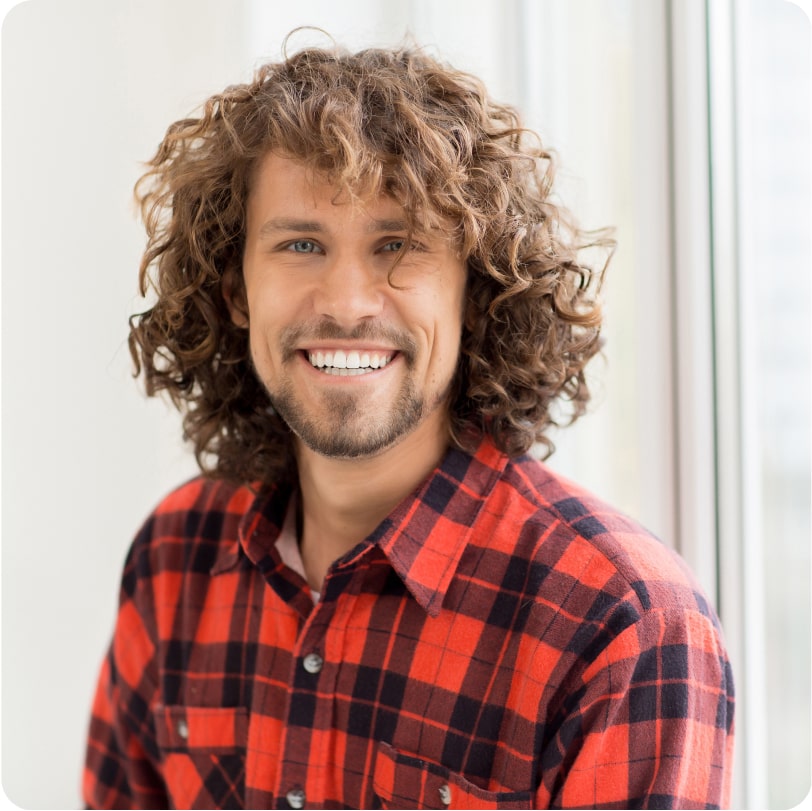 Young man smiling wearing plaid shirt